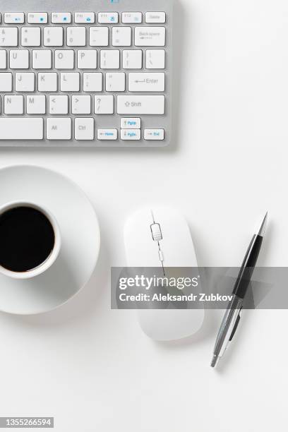 a wireless keyboard and mouse from a laptop, a mug with black coffee, on a white background or a desktop. subjects of a businessman or freelancer. business concept. coffee break. the concept of technology. - office desk top view stockfoto's en -beelden