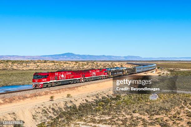 the legendary ghan tourist train with red engines in outback south australia with flinders ranges background - camel stock pictures, royalty-free photos & images