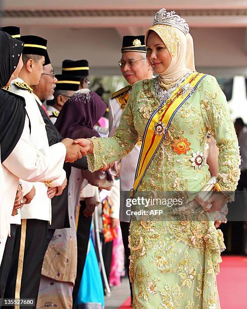 The outgoing 13th queen of Malaysia, Tuanku Nur Zahirah , greets officials during a farewell ceremony at the Parliment House in Kuala Lumpur on...