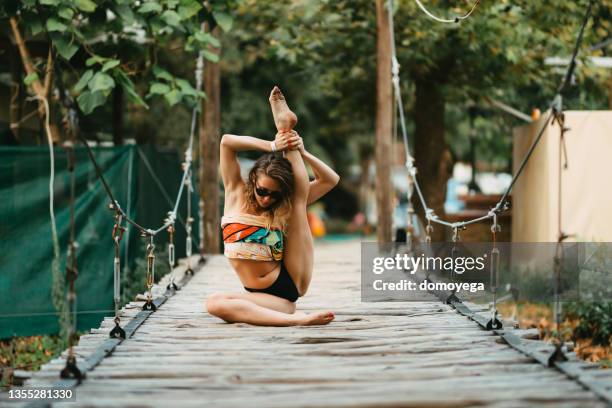 flexible woman stretching a practicing yoga during summer vacation - artistic gymnastics stock pictures, royalty-free photos & images