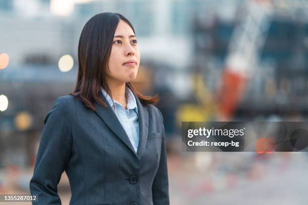 porträt einer ingenieurin auf der baustelle - japanese bussiness woman looking up stock-fotos und bilder