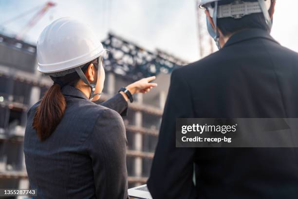 ingenieurinnen arbeiten gemeinsam auf der baustelle - foundations conversations with suits stock-fotos und bilder