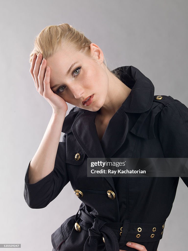 Girl wearing coat with hand on head