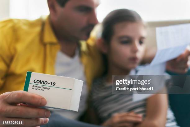 father taking care of his sick child. covid-19 pandemic - medicamento antiviral imagens e fotografias de stock