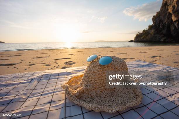 sunglass and sun hat on white sand beach in tropical beach in thailand - blue white summer hat background stock pictures, royalty-free photos & images