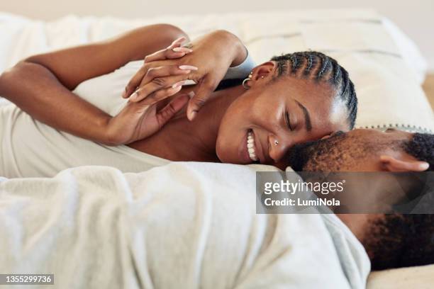 shot of a young couple being intimate in bed at home - man and woman cuddling in bed stockfoto's en -beelden