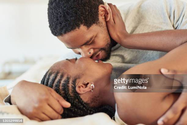 aufnahme eines jungen paares, das zu hause im bett intim ist - man and woman kissing in bed stock-fotos und bilder