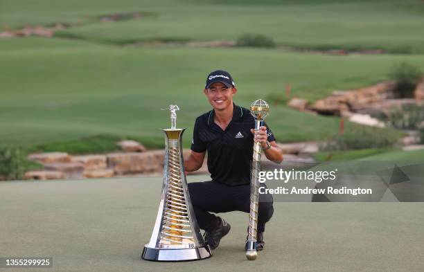 Collin Morikawa of the United States poses with both the Race To Dubai and the DP World Tour Championship trophies after winning The DP World Tour...