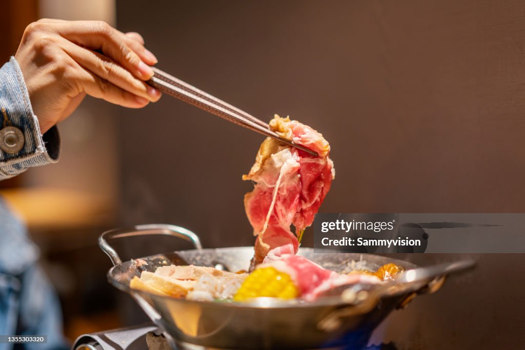 Tasting sukiyaki on the table