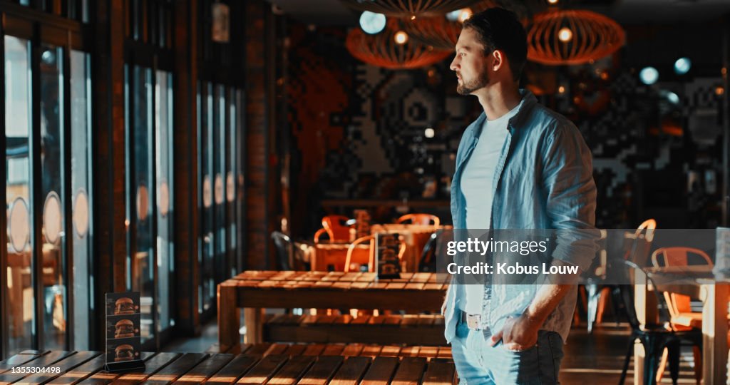 Shot of a young man looking thoughtful in a restaurant