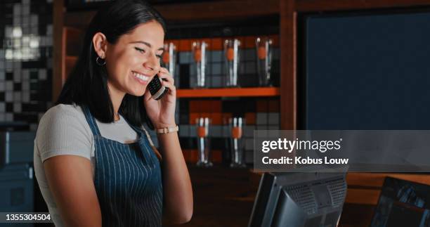 aufnahme einer jungen frau, die hinter dem tresen eines restaurants telefoniert - festnetztelefon stock-fotos und bilder