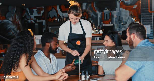 shot of a group of young friends paying the bill with a credit card at a diner - restaurant bill stock pictures, royalty-free photos & images