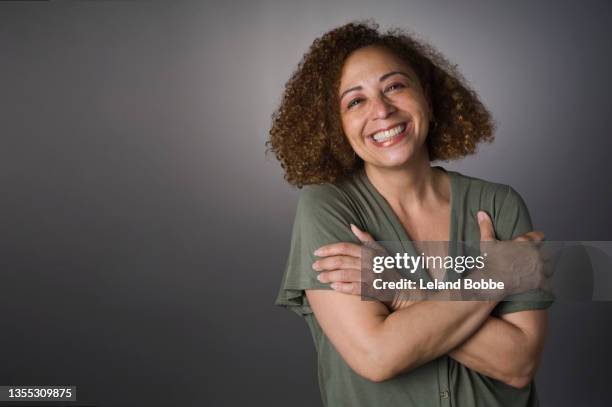 studio portrait of middle aged mixed race woman - oberkörper happy sommersprossen stock-fotos und bilder