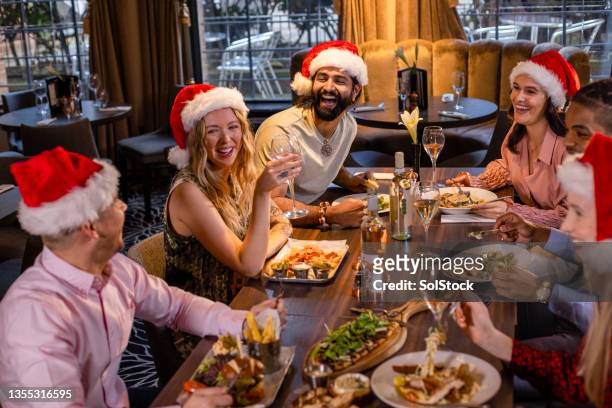 comida y bebidas navideñas con amigos - sombrero de fiesta fotografías e imágenes de stock