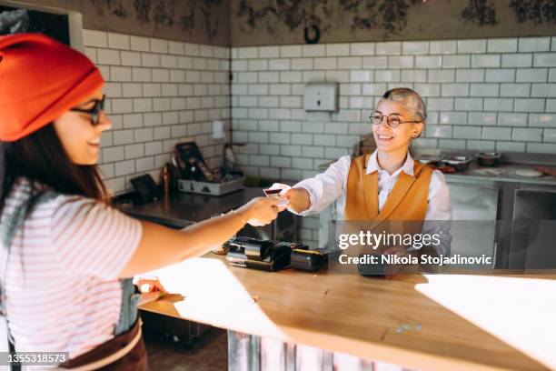 pays with plastic card in cafe for lunch - card payment stock pictures, royalty-free photos & images