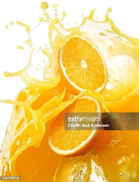 oranges with splashing orange juice. - orange juice stock-fotos und bilder
