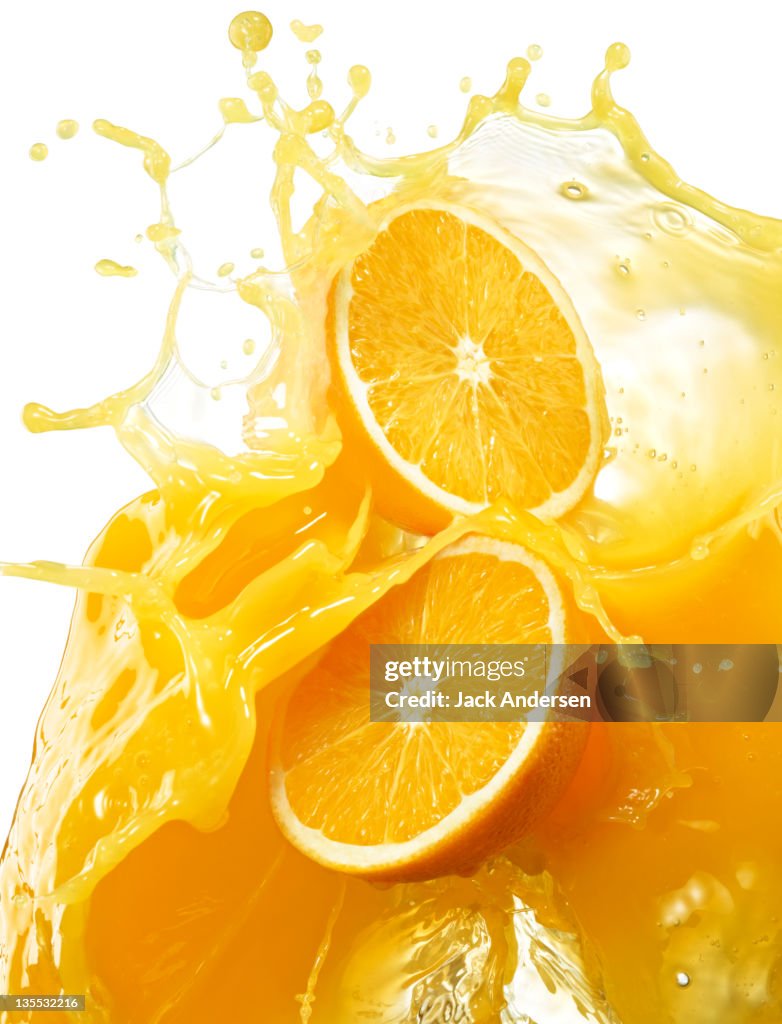 Oranges with splashing orange juice.