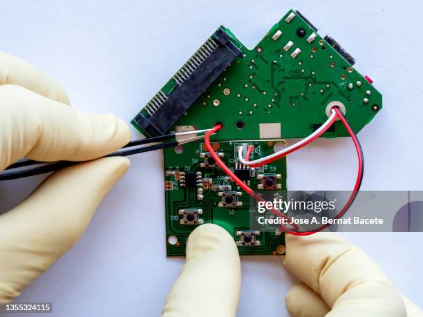 hands of an electronics technician repairing a printed circuit board - soldered stock pictures, royalty-free photos & images