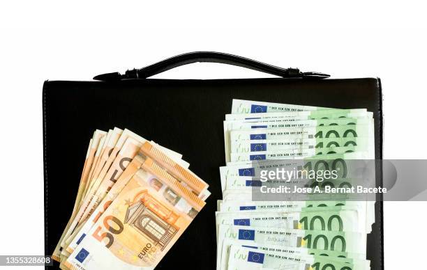 full frame business black briefcase with a lot of 100 and 50 euro bills on a white background. - evasión fiscal fotografías e imágenes de stock