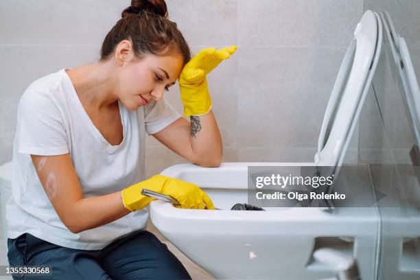 young girl housewife wearing yellow household gloves cleans the toilet bowl. house cleanliness, cleaning service - washing up glove stock pictures, royalty-free photos & images