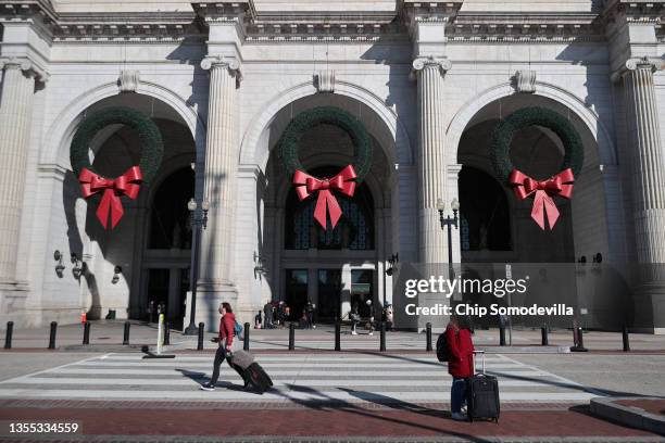 Giant wreaths with red bows hang in the archways in front of Union Station as passengers come and go the day before Thanksgiving on November 24, 2021...