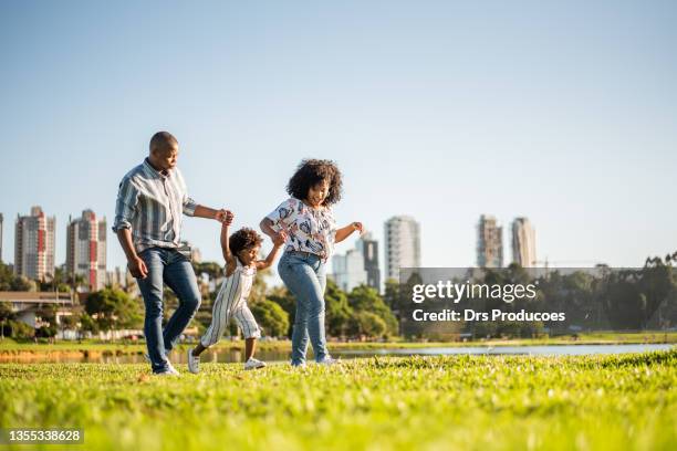 balade en famille en fin d’après-midi dans le parc de la ville - parents and children enjoying park photos et images de collection