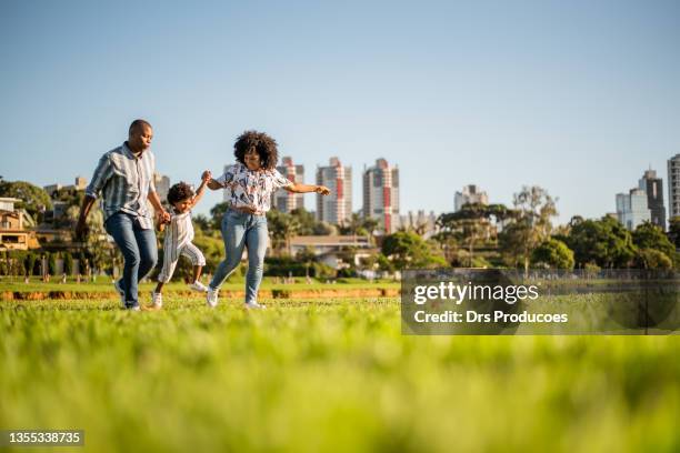 family playing around the lake in the city park - park family sunset stock pictures, royalty-free photos & images