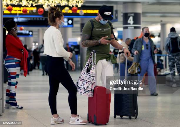 People arrive at the Miami International Airport terminal for a flight on November 24, 2021 in Miami, Florida. The Transportation Security...