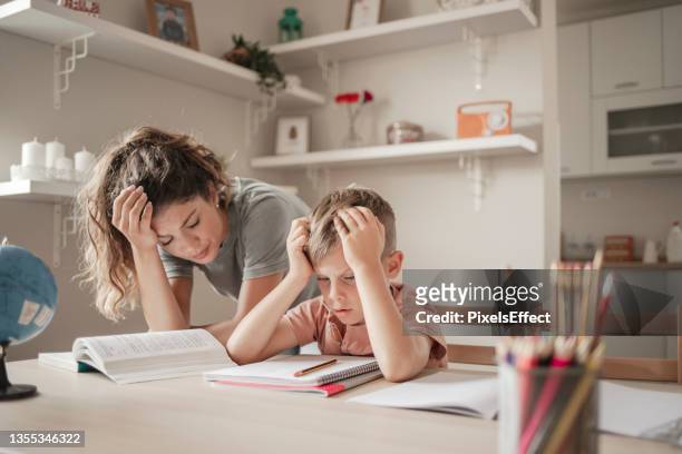 upset mother and her little boy doing homework - mother child homework stock pictures, royalty-free photos & images