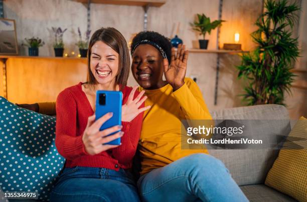 female friends making video call - friends laughing at iphone video stock pictures, royalty-free photos & images