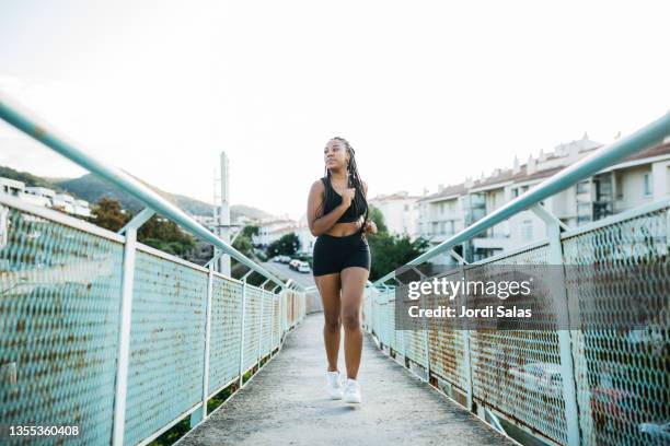 woman running on a urban bridge - voluptuous black women - fotografias e filmes do acervo