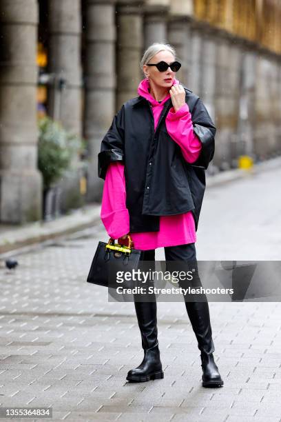 Best Ager Model and Influencer Petra van Bremen wearing a hot pink oversized hoodie by Balenciaga, a black jacket with short sleeves by Valentino,...