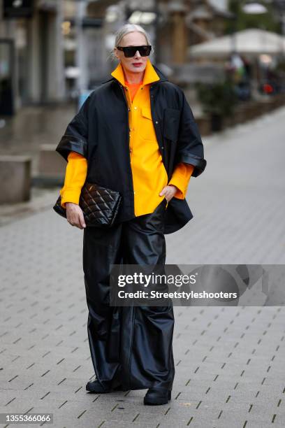 Best Ager Model and Influencer Petra van Bremen wearing a neon orange t-short by Balenciaga, a yellow oversized jacket by Off-White, black leather...