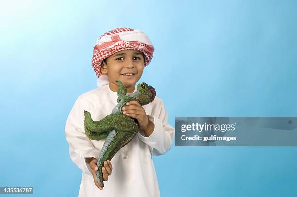 arab boy playing with toy dinosaur - two young arabic children only indoor portrait stock pictures, royalty-free photos & images