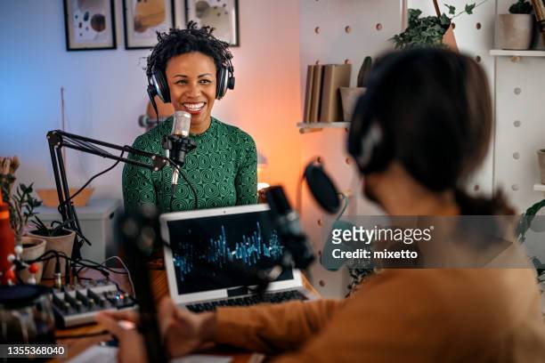 une jeune femme enregistre un podcast sur une interview d’un homme en studio - animateur radio photos et images de collection