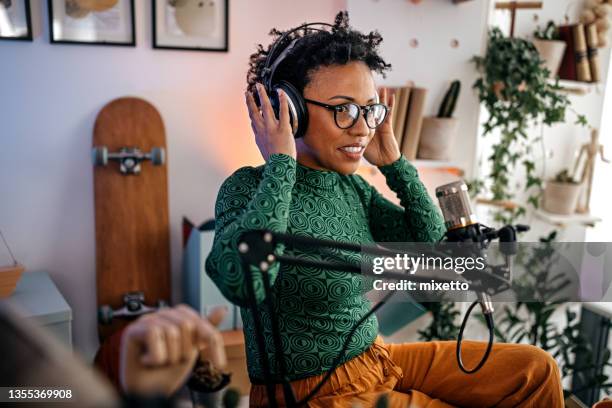 woman setting headphones for podcast recording - interview preparation stock pictures, royalty-free photos & images