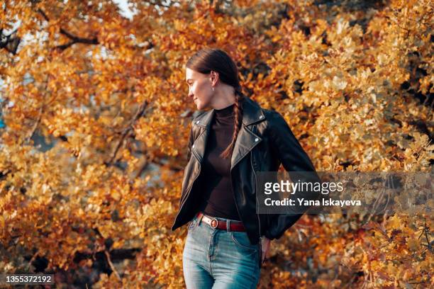 young european woman enjoying autumn forest and relaxing in the sun - black jeans stock pictures, royalty-free photos & images
