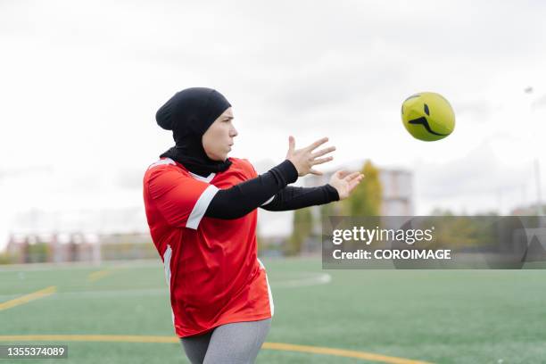 arab athlete woman throwing a rugby ball during a training on the field. - rugby icon stock pictures, royalty-free photos & images