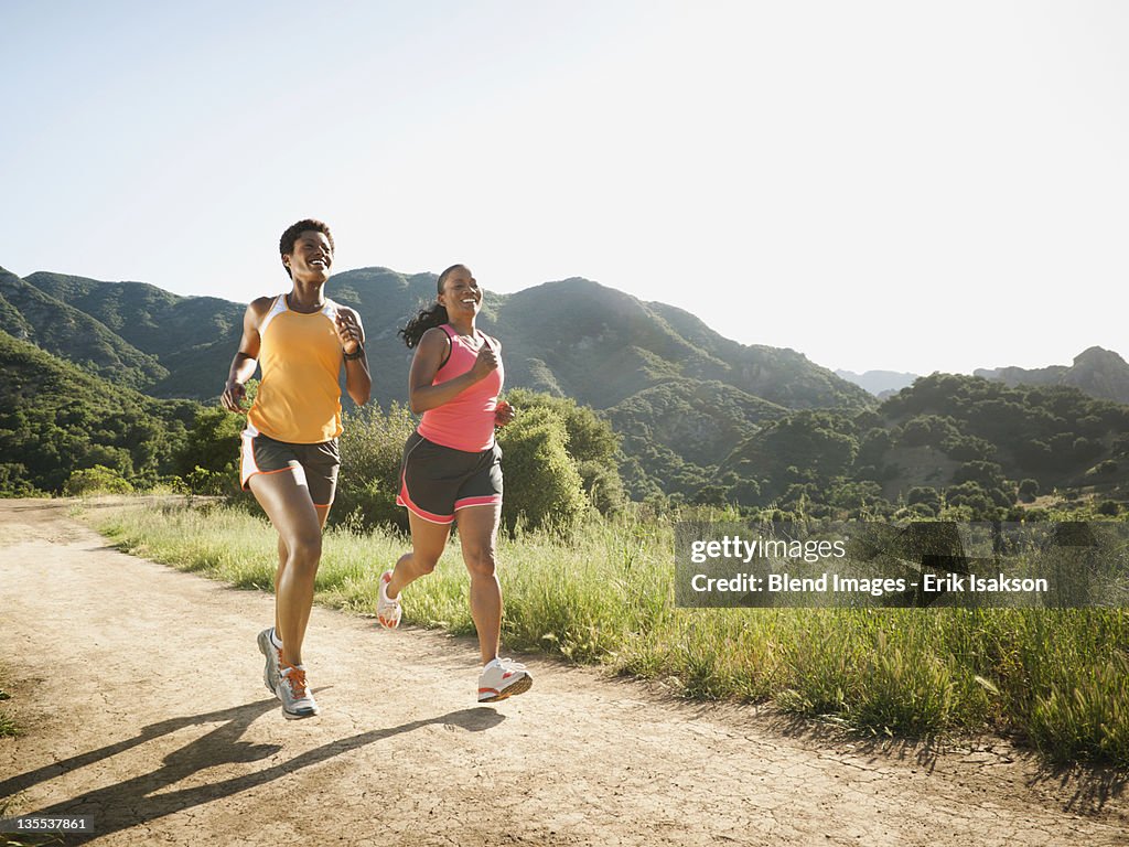 Women running together on remote trail