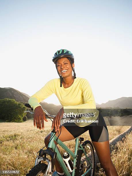 mixed race biker standing with mountain bike - black woman riding bike stock pictures, royalty-free photos & images