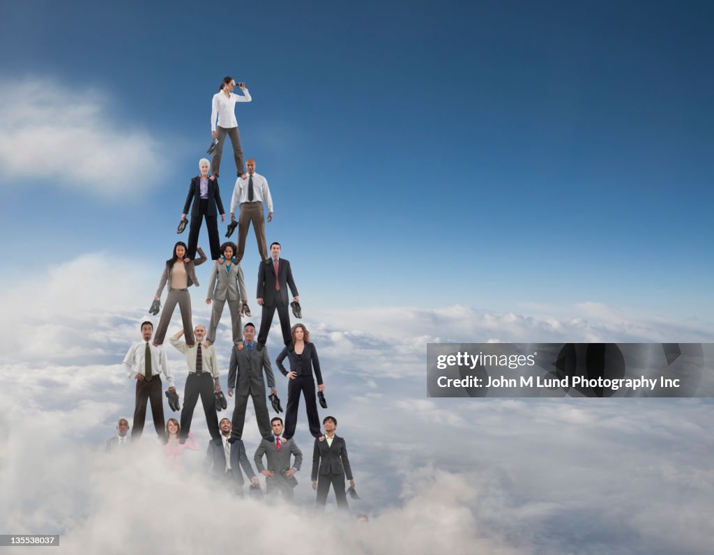 Business people making a human pyramid