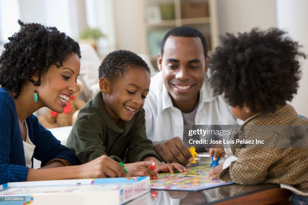 African American family playing board game together