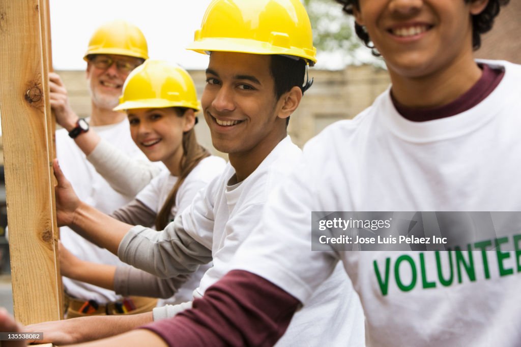 Volunteers lifting construction frame together