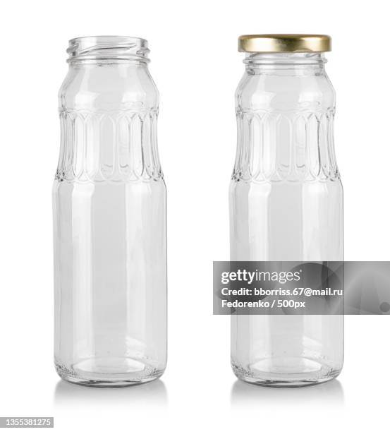 close-up of empty glass bottles against white background - キャニスター　ガラス ストックフォトと画像