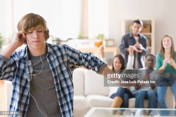 teenagers hanging out together - young boy enjoying music stock-fotos und bilder