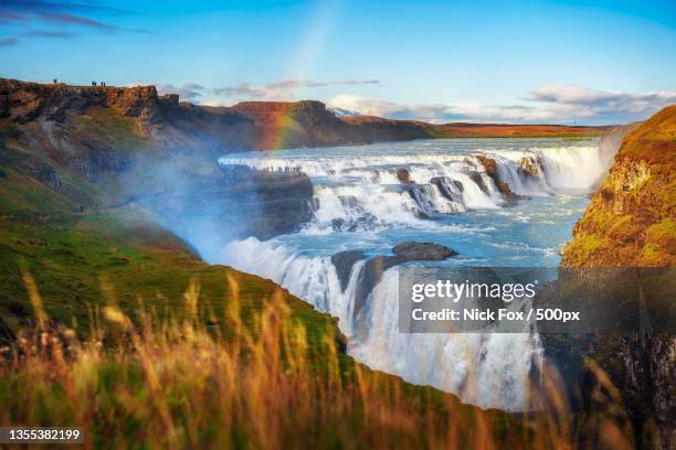 scenic view of waterfall against sky - gullfoss falls stock-fotos und bilder