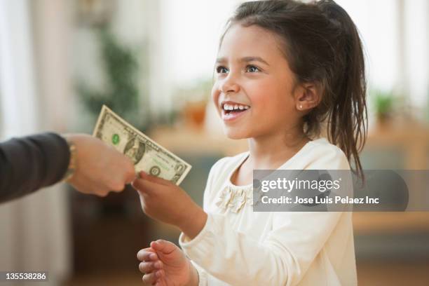 mother handing girl one dollar bill - kids money fotografías e imágenes de stock