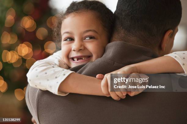 father hugging daughter at christmas - papa noel stockfoto's en -beelden