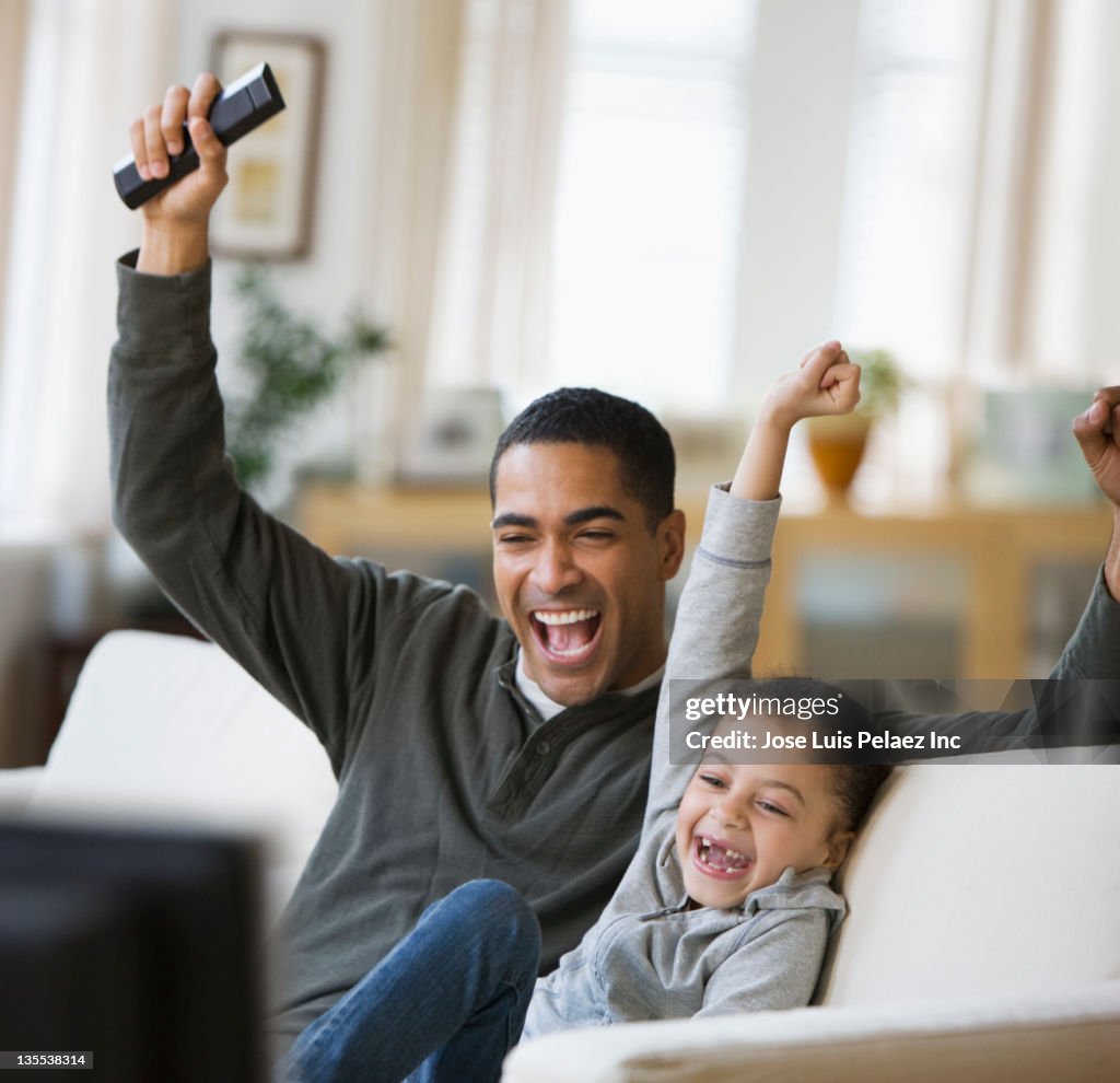 Father and daughter watching television together