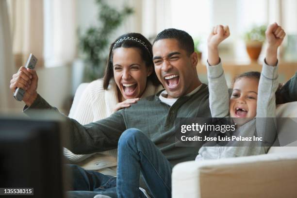family watching television together - family excitement stock pictures, royalty-free photos & images